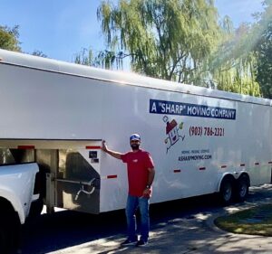 Mover standing next to our moving trailer on a move in Sherman TX